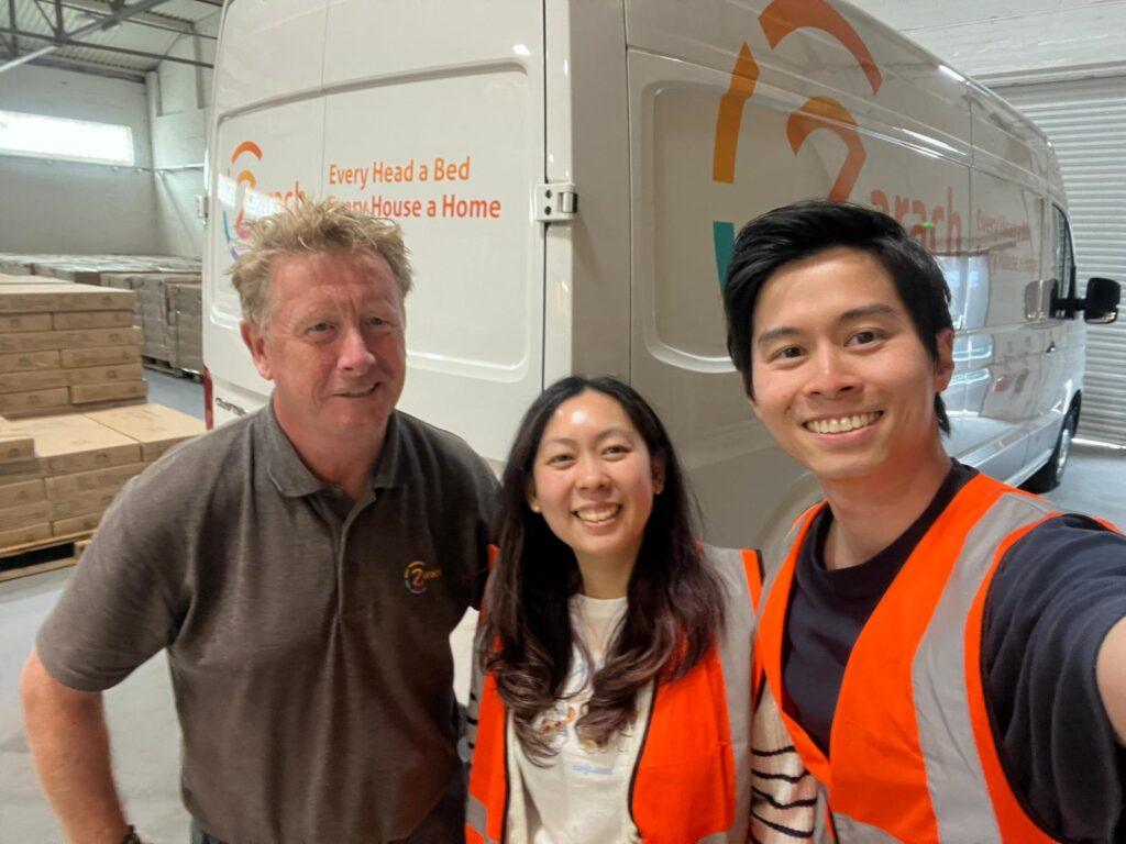 Three people in safety vests indoors.